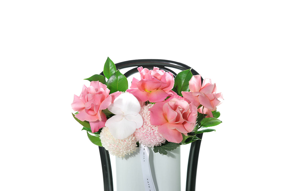 Kate Hill Flowers – soft-pink birthday vase with chrysanthemums, blush roses and orchids in a white wave ceramic.