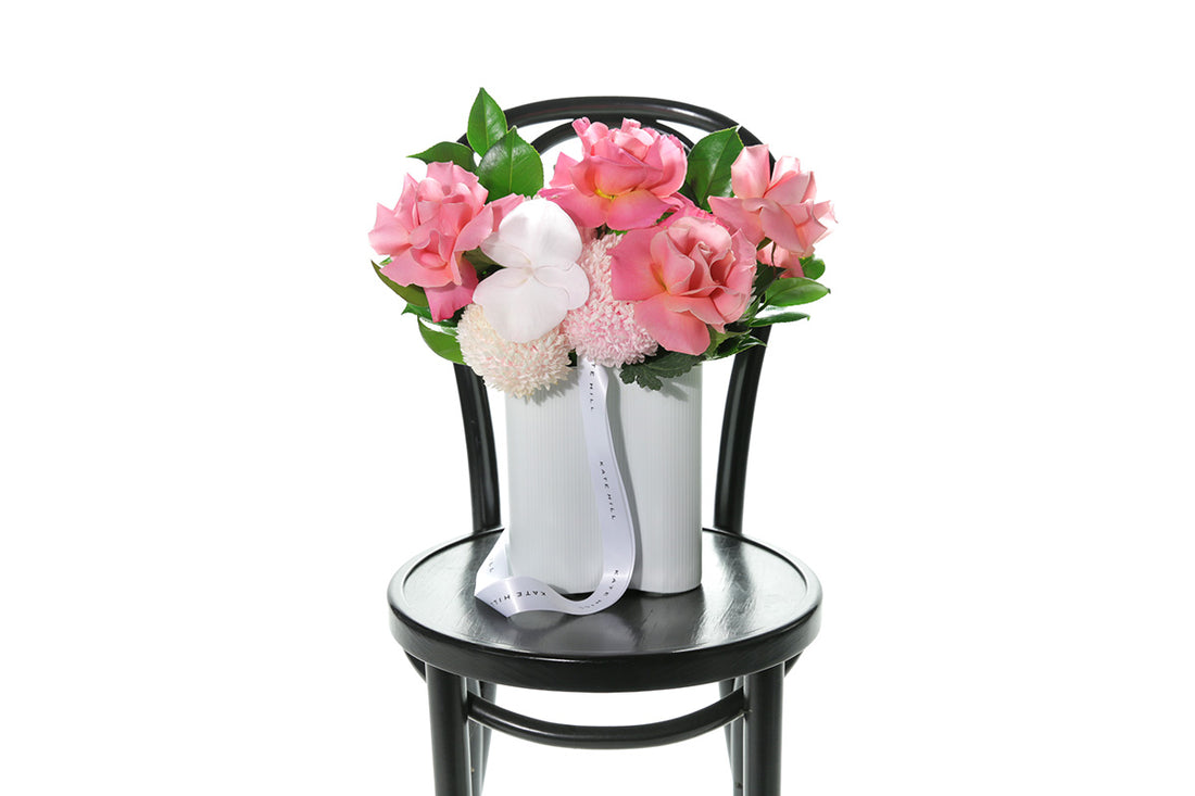 Kate Hill Flowers – soft-pink birthday vase with chrysanthemums, blush roses and orchids in a white wave ceramic.