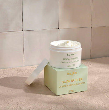 Huxter body butter jar and box on a neutral background
