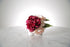 Kate Hill Flowers artificial burgundy peony and blush hydrangea wrist corsage on silver elastic wristlet displayed on a marble table with a white background.