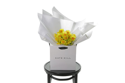 Petite posy of wrapped Daffodils, sitting on a black bentwood chair. Classed as a small in size, the DAFFODIL is a hand tied collection of 3 bunches of DAFFODILS which are beautifully gift wrapped in our signature wrapping. Yellow double daffodils in image.