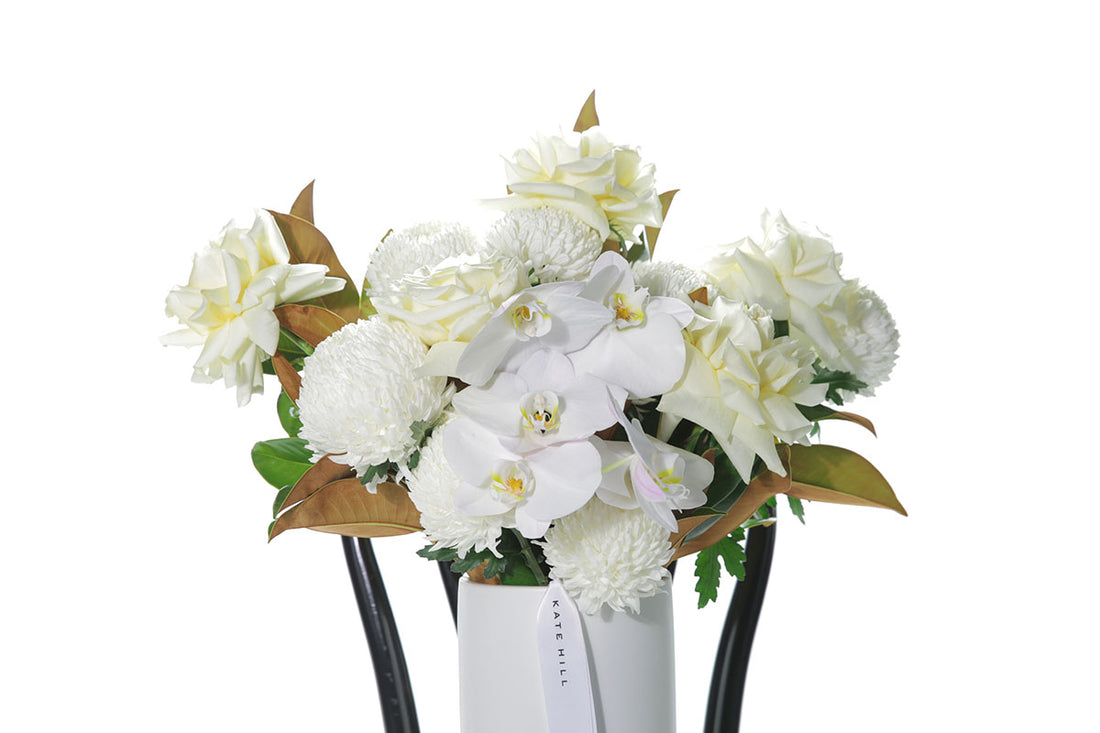 Kate Hill Flowers – white chrysanthemum sympathy ball-vase design with monstera leaf lining.
