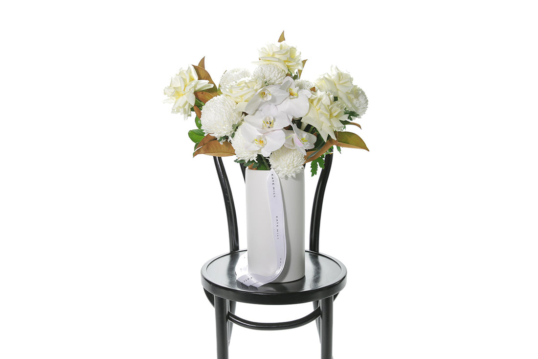 Kate Hill Flowers – white chrysanthemum sympathy ball-vase design with monstera leaf lining.