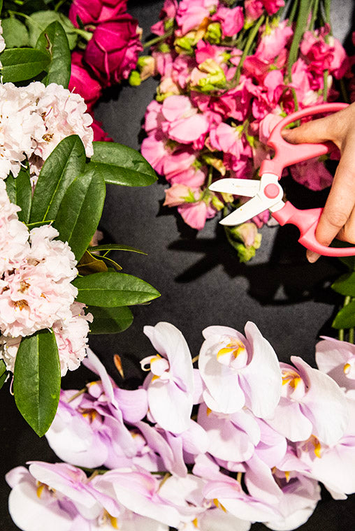 Florist cutting flowers on a bench getting ready for delivery to Bentleigh. 