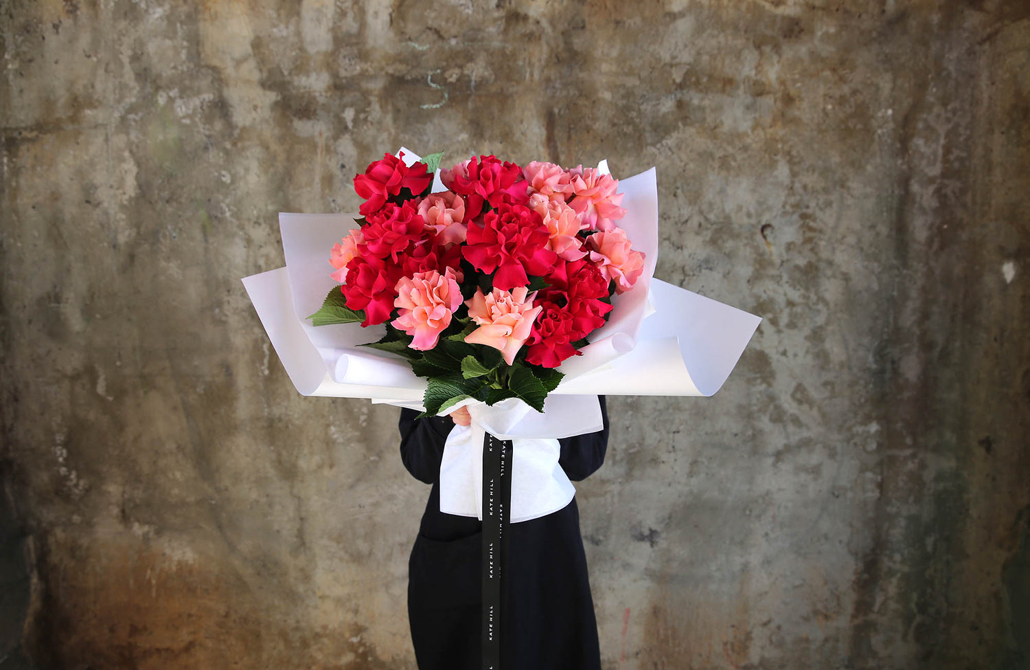 Melbourne Florist holding flower bouquet in red tones