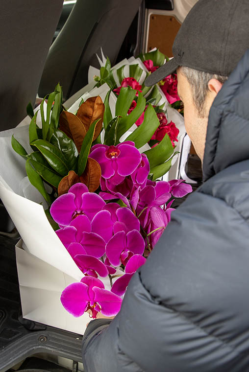 Flower delivery driver loading flowers into delivery van 