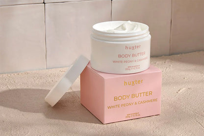 Hustler white peony and cashmere Body Butter jar and packaging on a neutral bathroom style background