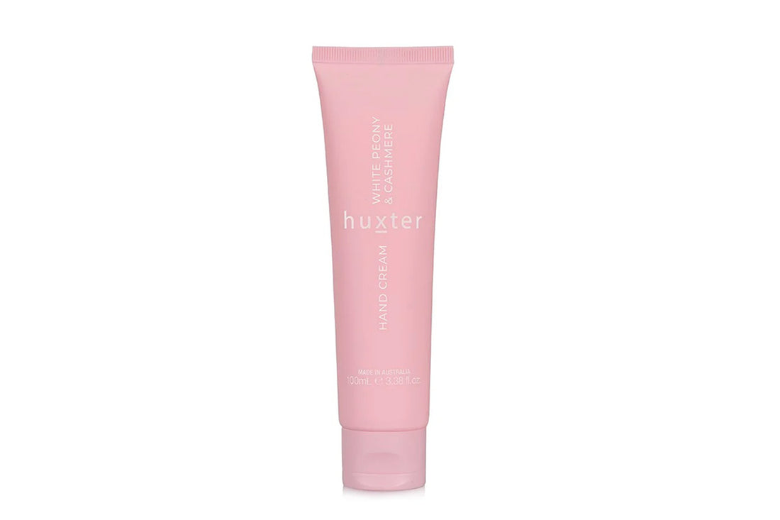 Pink tube of Huxster hand cream on a white background