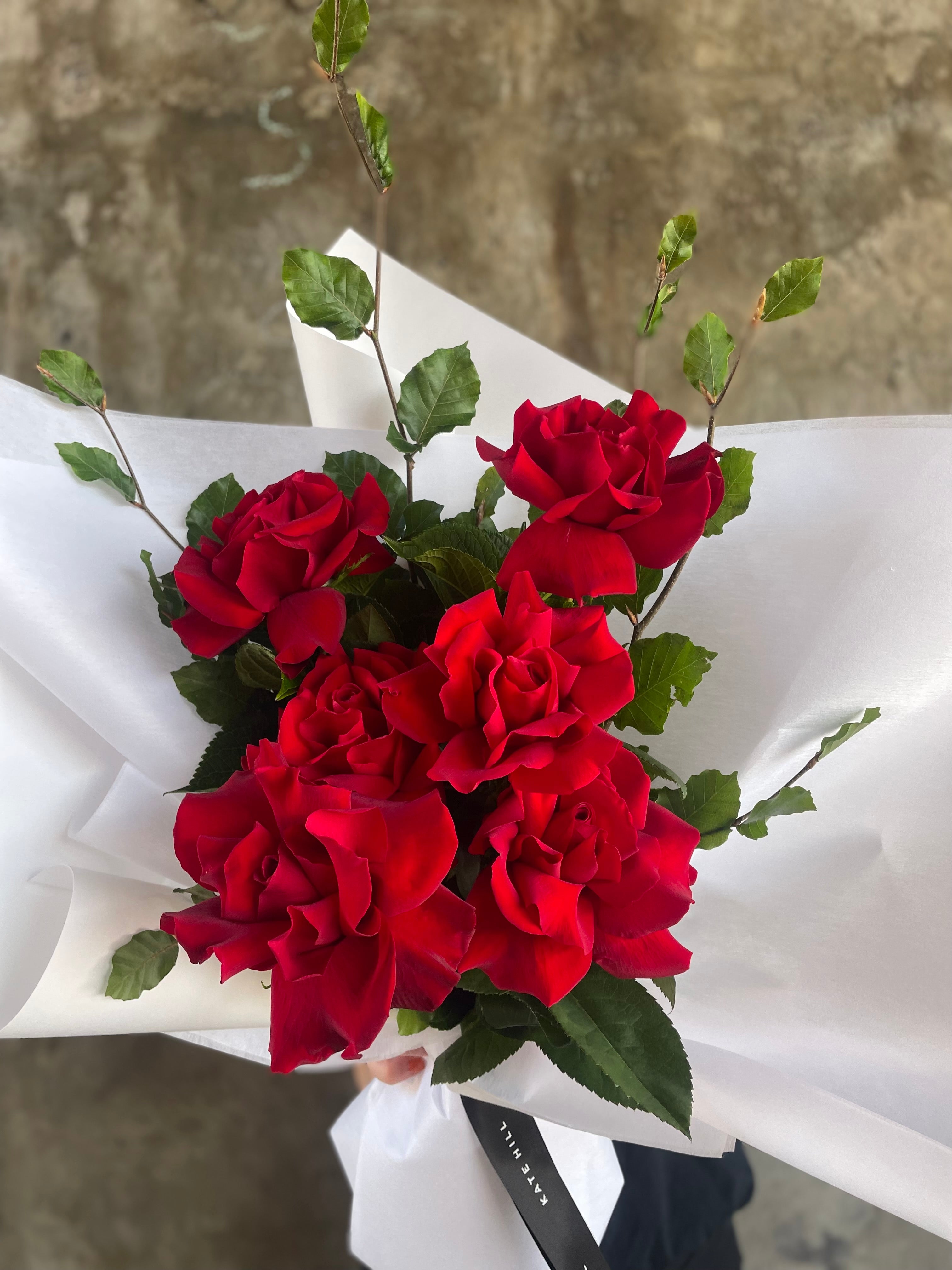 Close up image of the red rose bouquet. Simple red rose bouquet displaying 6 stems of red reflexed roses. Valentines day or Romance gift bouquet 