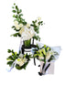 A grouping of Christmas Flower bundle including ball vase, bouquet and large vase design with a white wall backing.