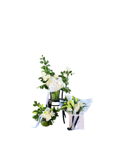 A grouping of Christmas Flower bundle including ball vase, bouquet and large vase design with a white wall backing.