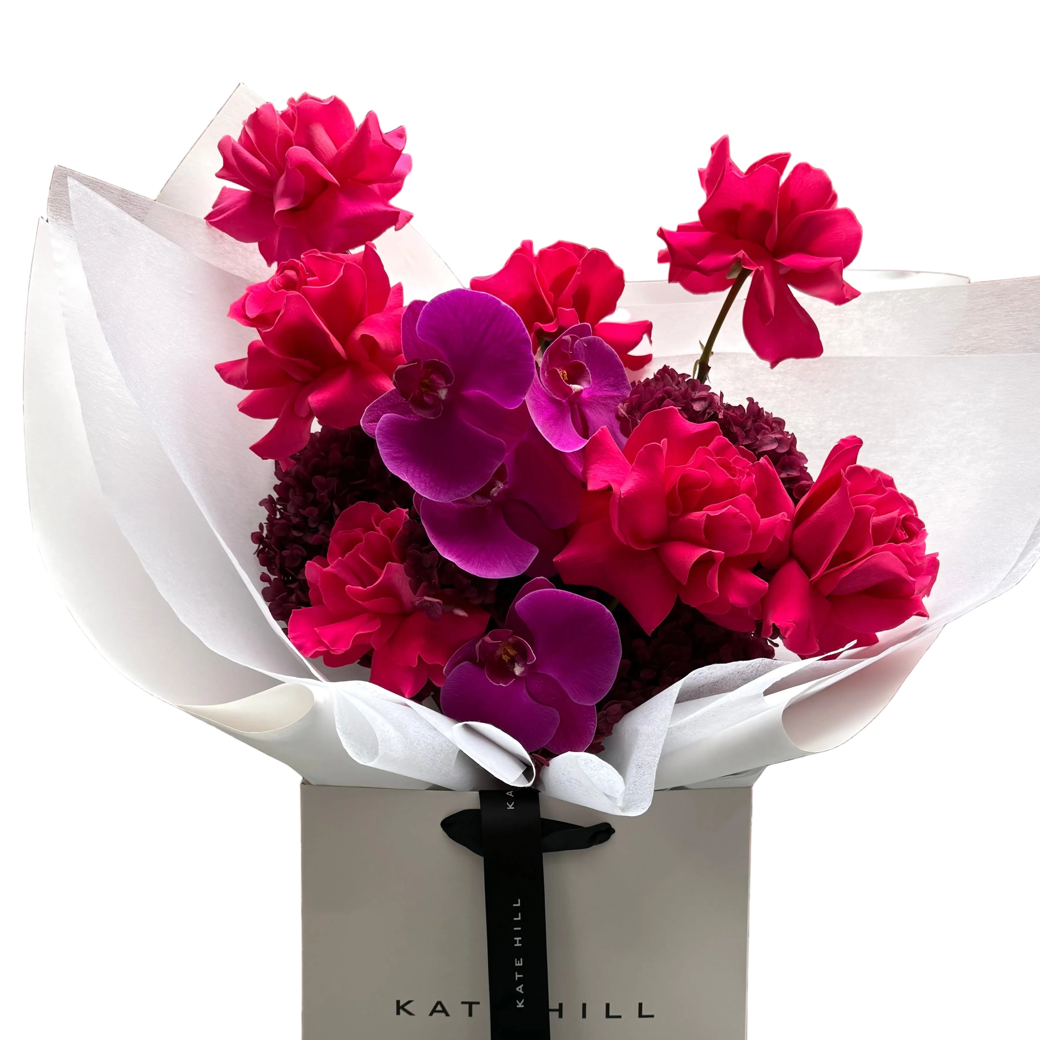 June signature flower bouquet featuring bright pink tones on black chair.