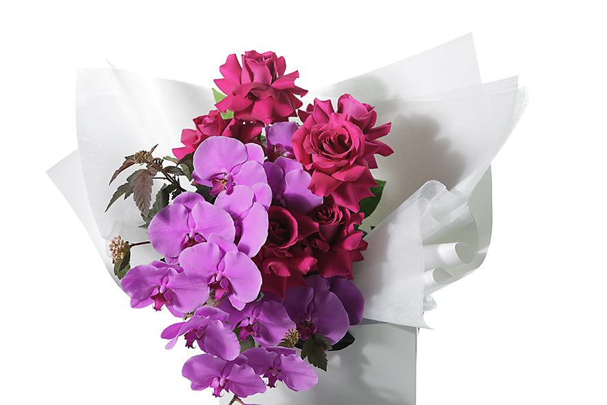 Kate Hill Flowers – large pink orchid and hot-pink rose graduation bouquet, hand-tied with a white background.
