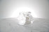 Petite white phalaenopsis orchid bridesmaid bouquet with satin ribbon and pearl pin finish on a marble surface