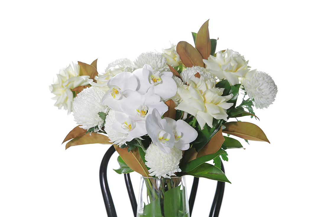 Kate Hill Flowers – large tapered vase with white and lemon roses, chrysanthemums, orchids and monstera lining.