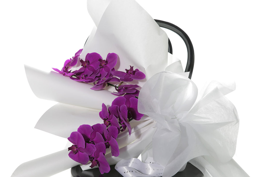 Kate Hill Flowers – gift-wrapped magenta Phalaenopsis orchid bouquet with two water-vialled stems.