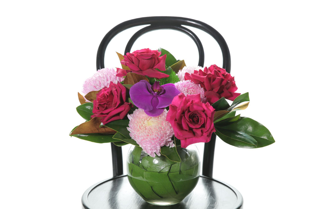 Kate Hill Flowers – bright pink ball-vase birthday design with chrysanthemums, reflexed roses and magenta orchid.
