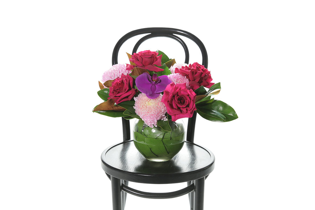 Kate Hill Flowers – bright pink ball-vase birthday design with chrysanthemums, reflexed roses and magenta orchid.