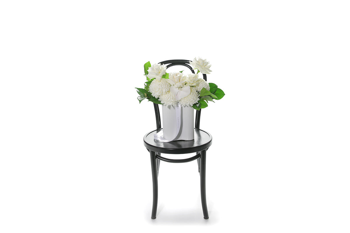 Kate Hill Flowers – medium white sympathy vase with roses, chrysanthemums, orchids and greenery in a wave-ceramic vessel.