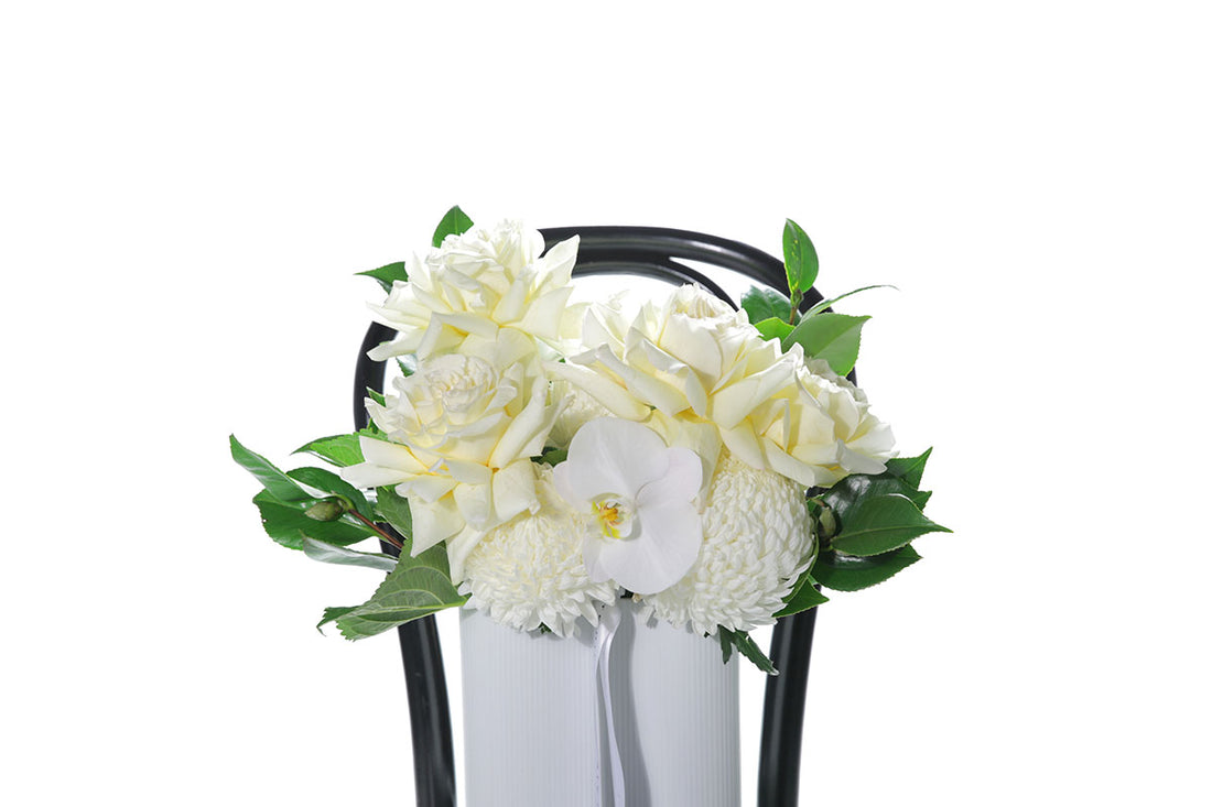 Kate Hill Flowers – white and lemon congratulations vase with roses, chrysanthemums, orchids and foliage in a white wave ceramic.