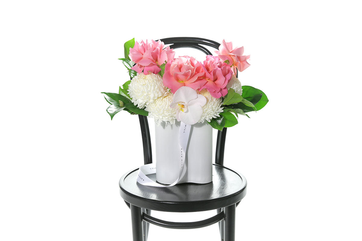 Kate Hill Flowers – medium white wave vase with white disbuds, blush roses and blush orchids.