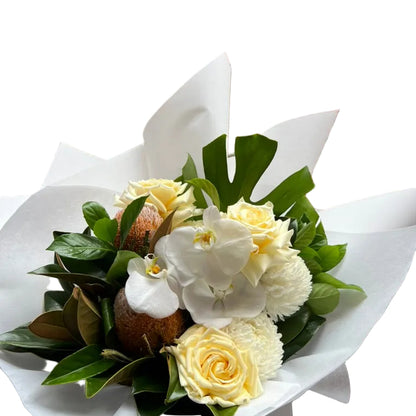 Close up of our October Birthday Bouquet featuring lemon roses, banksias, white disbuds, white orchid and seasonal foliage. Presented beautifully in our signature white wrapping.