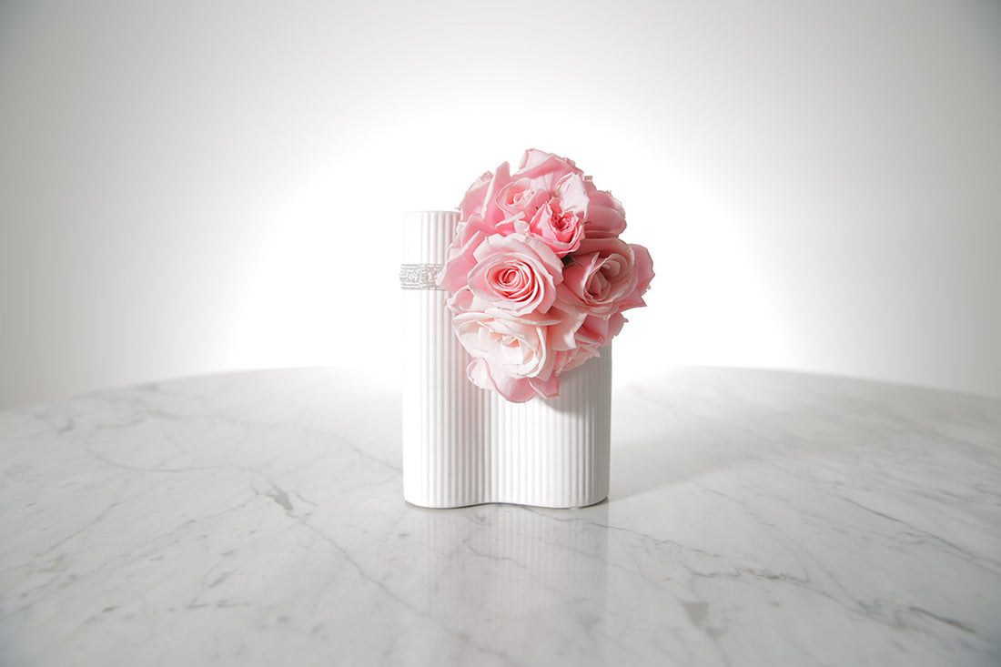 Kate Hill Flowers pink spray rose wrist corsage on a silver elastic wristlet on a marble surface