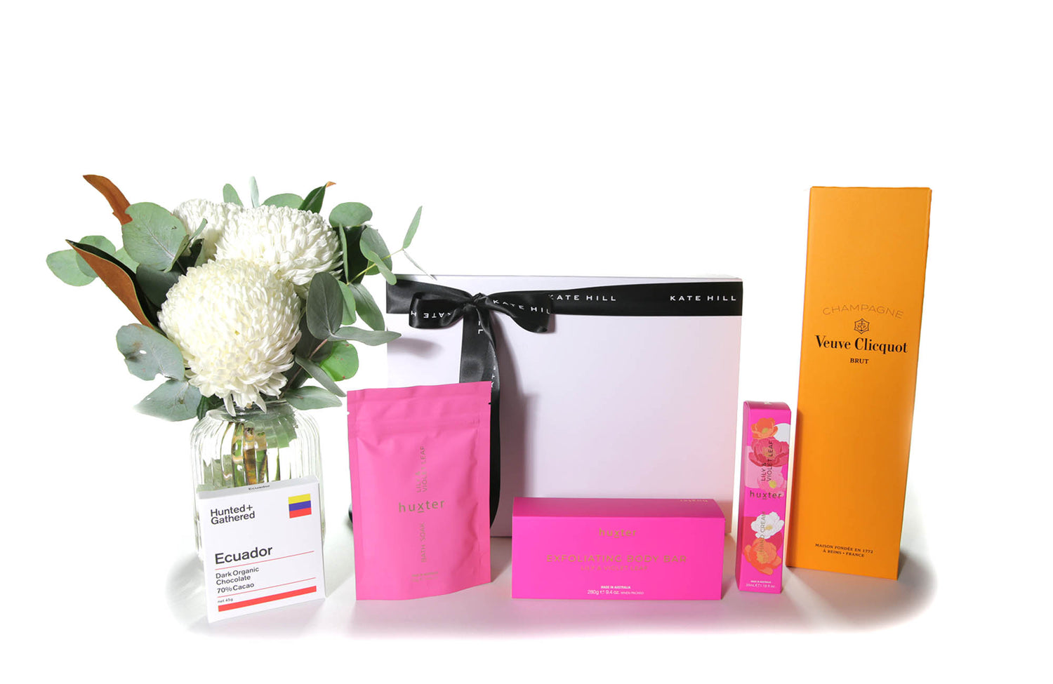 Flower gift box hamper featuring a chic flower vase design, chocolate,  French Champagne, body care products and a teddy bear. 