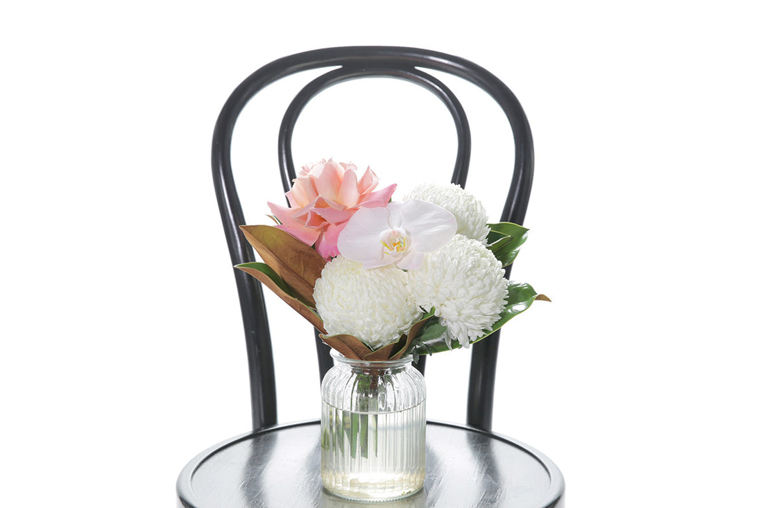 Kate Hill Flowers – small ribbed jar vase with blush orchid, white disbud, pink rose and magnolia foliage.