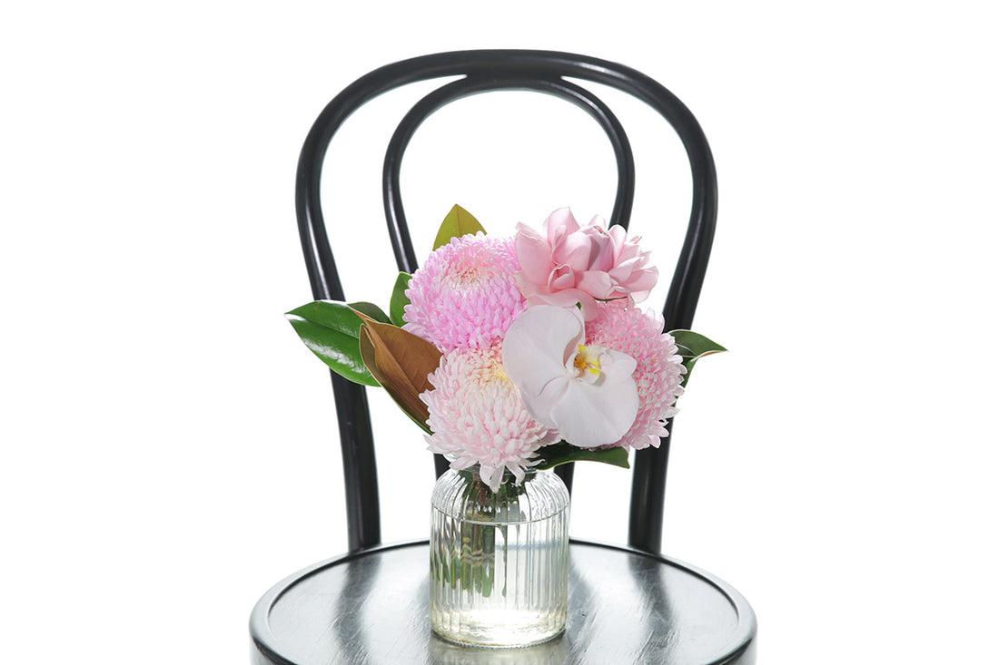 Kate Hill Flowers – small soft-pink birthday vase with chrysanthemum, rose, orchid and foliage in a ribbed jar.