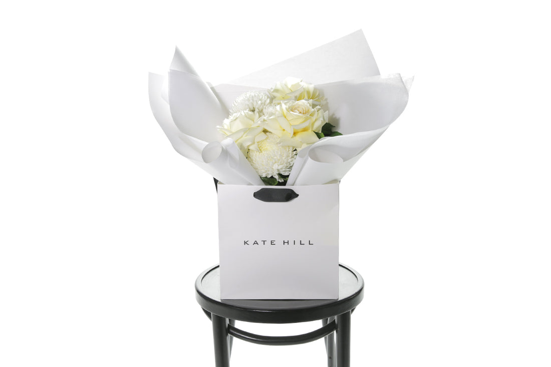 Kate Hill Flowers – small white and lemon congratulations posy of roses and chrysanthemums in a luxury flower bag.