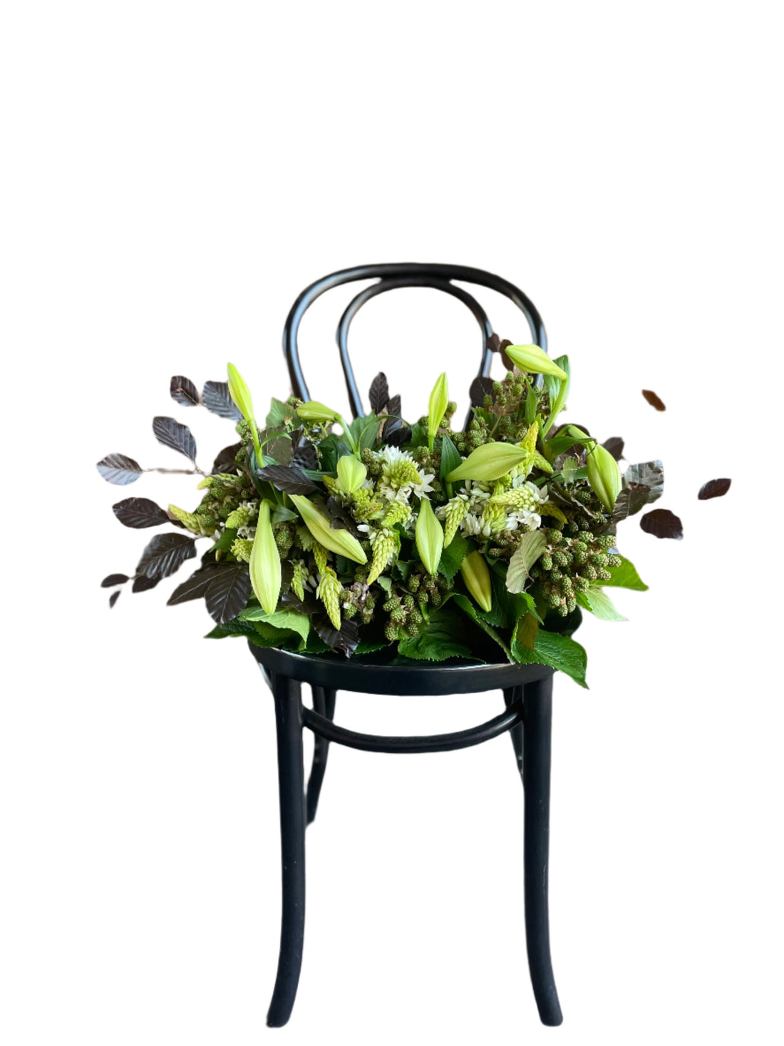 A Christmas Table Design sitting on a black bentwood chair with a white wall background.