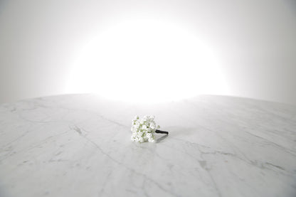White flower boutonniere buttonhole flowers on a marble surface with a white background