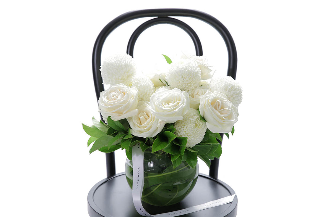 Close-up of ELISE large ball vase with white disbuds and roses