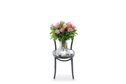 HERMOSA watermelon roses in a tapered glass vase lined with monsteria