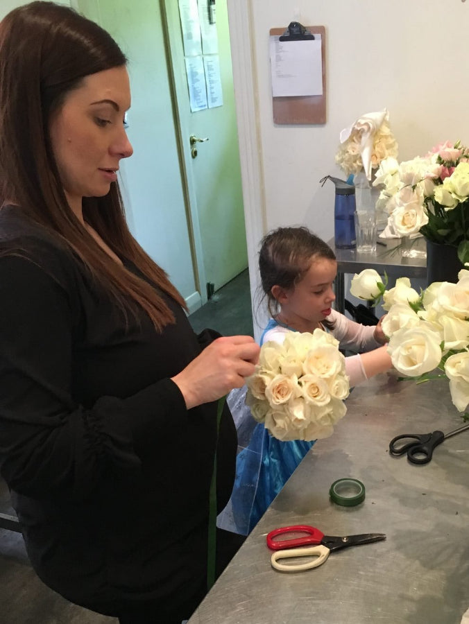 Kate Hill's daughter making a white rose posy beside her at the Prahran studio bench
