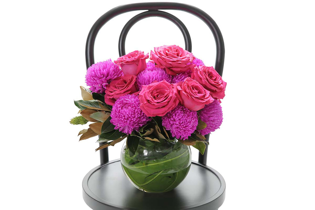Close-up of MAYA large ball vase with hot pink disbuds and roses
