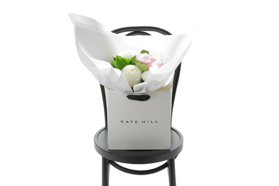 SERENITY Floral arrangement in a white box on a black chair with &