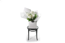 Large white rose bouquet displaying 6 stems of reflexed roses and green seasonal foliage. Presented beautifully in white signature wrapping and in Kate Hill Flower Bag. Wide image of the Blanca rose flower bouquet to give you an idea of the honest size of bouquet.