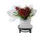 Classic and large red rose bouquet displaying 12 stems of red reflexed roses and seasonal green foliage. Valentines day or Romance gift bouquet presented in our Kate Hill Flower Bag. DIOR boasts a collection of short to medium-length red roses intertwined with seasonal foliage. Bouquet Bag sitting on a black bentwood chair.