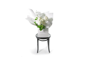 Chic, large and luxe bouquet featuring pure white phalaenopsis orchid stems, white reflexed roses and seasonal green foliages. Gift bouquet presented in Kate Hill Flower Bag. Wide image so you can see the true size of the bouquet bag.