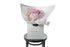 Small chic bouquet displaying a dome of pink hydrangeas (no additional foliage). Bouquet presented in Kate Hill Flower Bag. Bouquet bag sitting on black bentwood chair with white background.