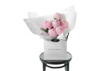 Pink Big Mom Disbud Gift Bouquet displaying 10 stems of pink Disbuds (no additional foliage) flower only. Gift Bouquet presented in Kate Hill Flower Bag. Bouquet bag sitting on a black bentwood chair.