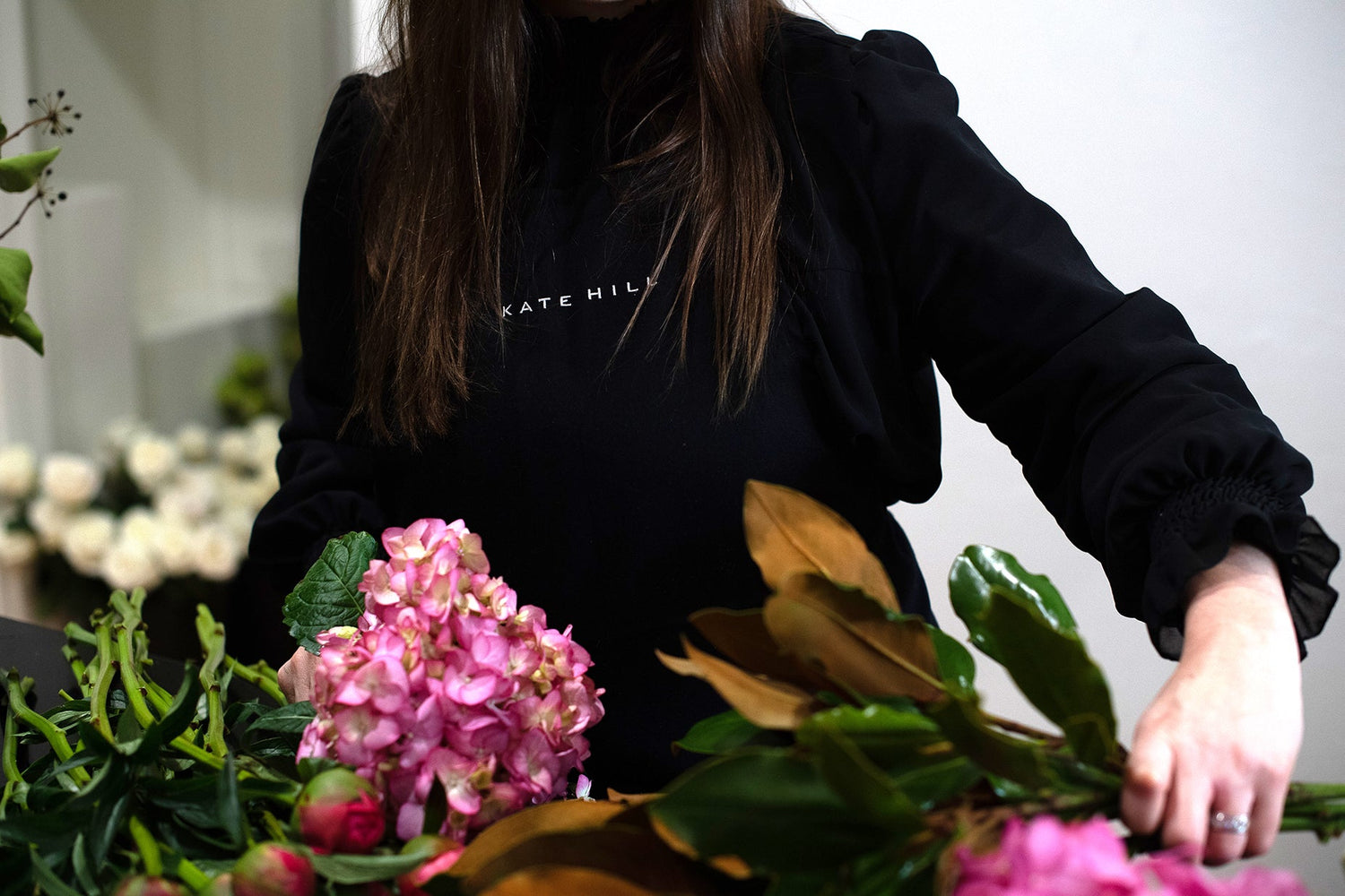 Kate Hill on the bench creating flowers including peonies, hydrangeas and foliages.